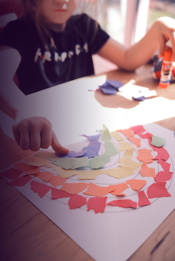Kind speelt met verschillende kleuren papier