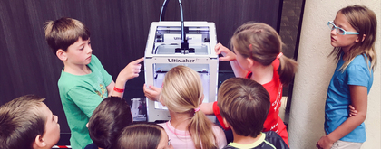 Kinderen bekijken een 3D printer van UltiMaker